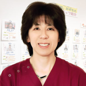 介護施設のスタッフの顔写真。赤いユニフォームを着た職員のプロフィール画像
