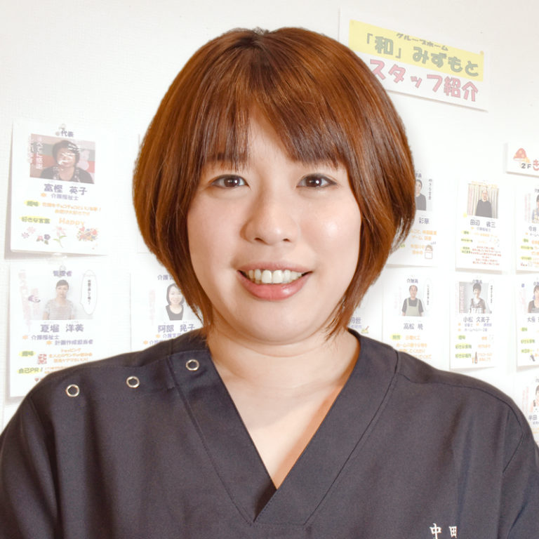 施設スタッフの顔写真。背景に職員紹介の掲示が見える。